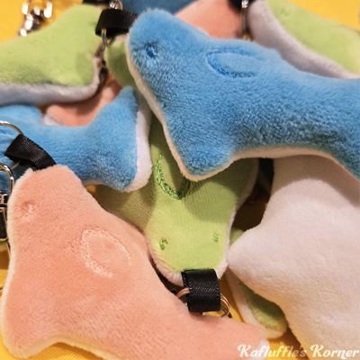 A plush pile of green, blue, and pink gummy shark keychains